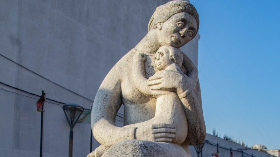 El rostro del niño, asustado, contrasta con el dulce rostro  la madre que lo arropa con amor.