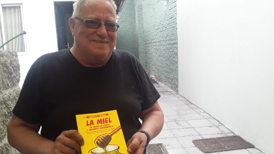 El vecino Pascual Tancredi con una de las ediciones del libro sobre la miel, que recientemente fue declarado de interés provincial por la Cámara de Diputados de la provincia de Buenos Aires.