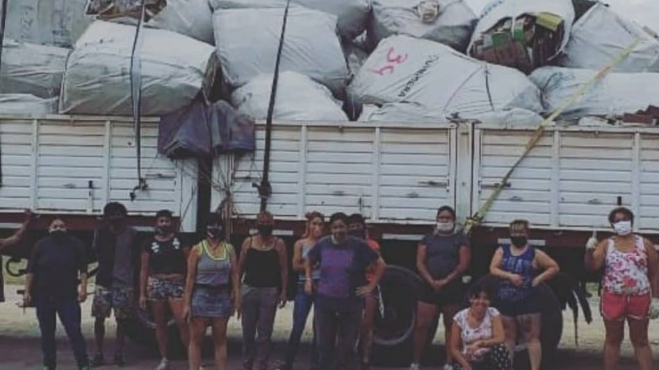 Integrantes de la cooperativa cartonera que funciona en Azul, al pie de uno de los camiones cargados con materiales reciclados.