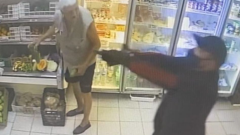 uno de los delincuentes, apuntando en el interior del negocio a quienes resultaron víctimas de este ilícito. IMAGEN DE VIDEO