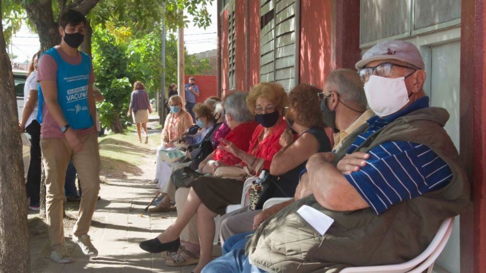Vecinos mayores de 70 años esperan en la puerta de la Escuela Nº 14 para recibir la vacuna contra el COVID-19.