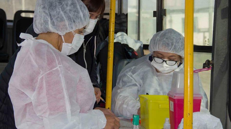 El equipo de vacunadores en plena faena, hoy de 10 a 13 el bus estará vacunando en el sector de Plaza Italia, en el barrio Del Carmen. VACUNATE AZUL