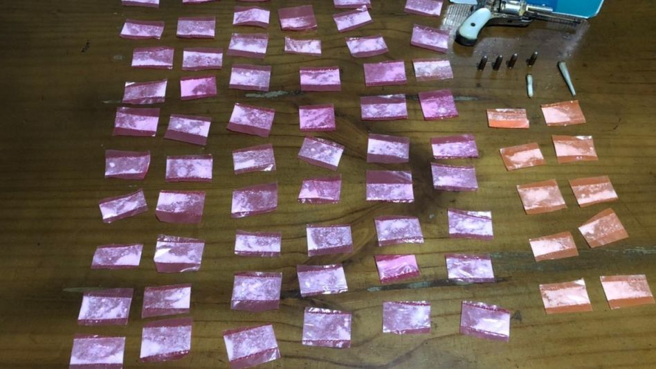 Los envoltorios con cocaína y el arma de fuego hallados en poder del hombre arrestado en jurisdicción de Azul este jueves que pasó en horas de la noche.VIAL AZUL/PBA
