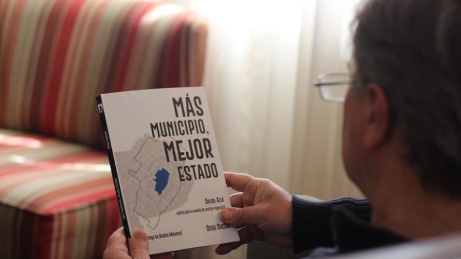 El ex intendente de Azul, Omar Duclós, posando con uno de los ejemplares de su libro Más Municipio, Mejor Estado. Desde Azul,  aportes para un modelo de gestión progresista?. FACEBOOK/O. DUCLÓS