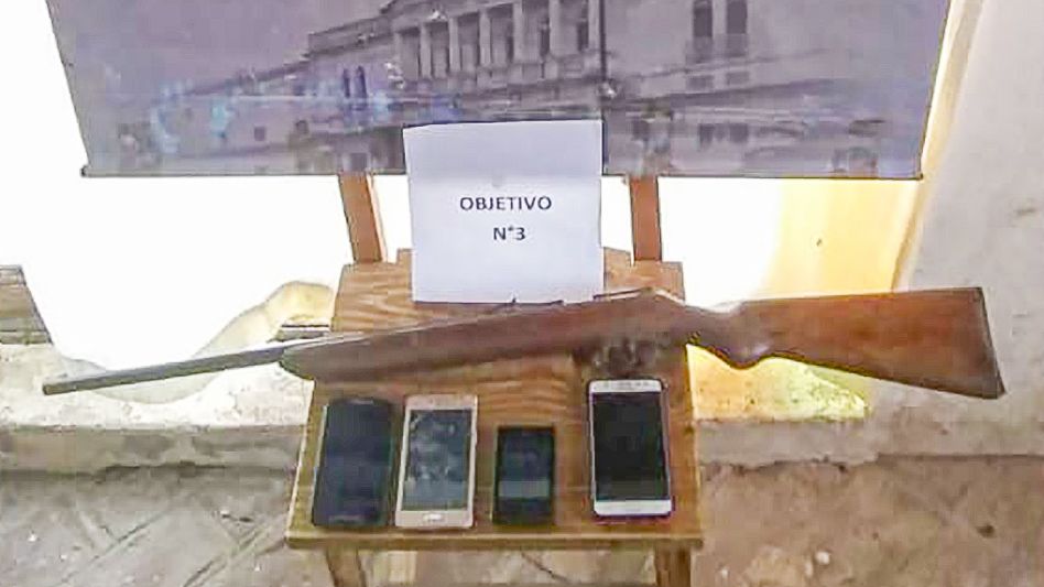 Dos de los imputados que tiene este sumario penal, un arma de fuego y teléfonos celulares.  FOTOS: CPR AZUL/PBA