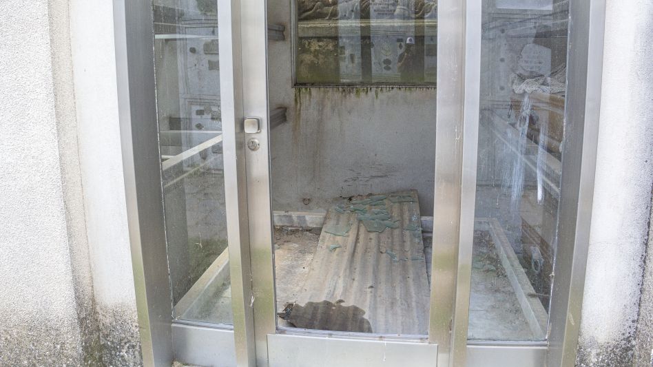 La puerta de una bóveda, con su vidrio completamente destrozado. Una de las imágenes que pueden verse en la actualidad en el Cementerio Municipal de Azul. NICOLÁS MURCIA