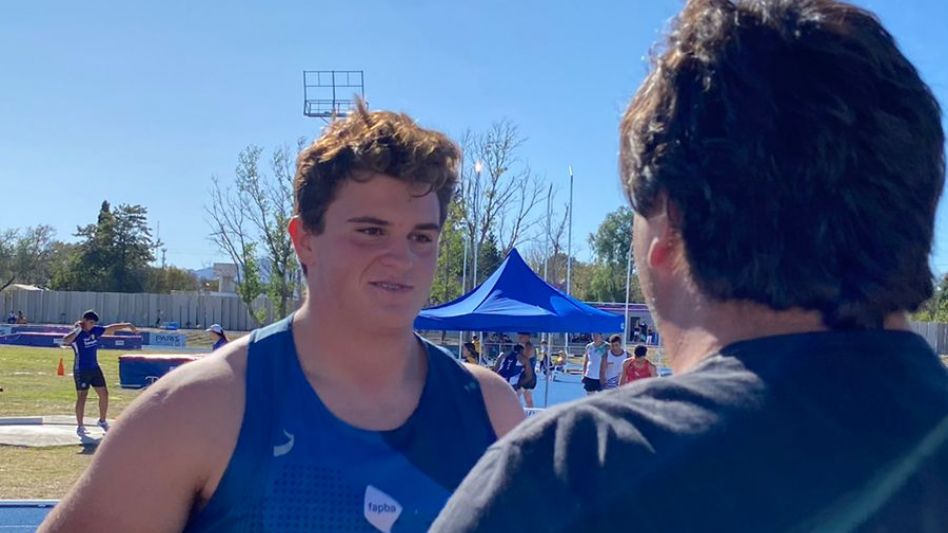 El entrenador Julio Piñero (de espalda) saluda a su pupilo Juan Arrieguez, quien volvió a romper su propio record provincial al registrar 19.03 mts. Foto: GENTILEZA ESCUELA MUNICIPAL