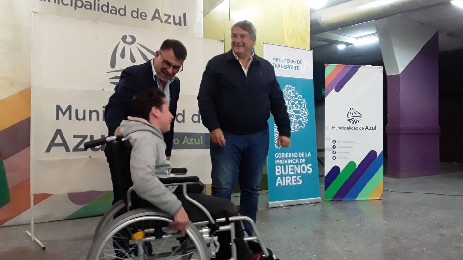 Hernán Bertellys y Jorge D?Onofrio durante la entrega del pase libre multimodal a una beneficiaria azuleña. AGUSTÍN SCALCINI