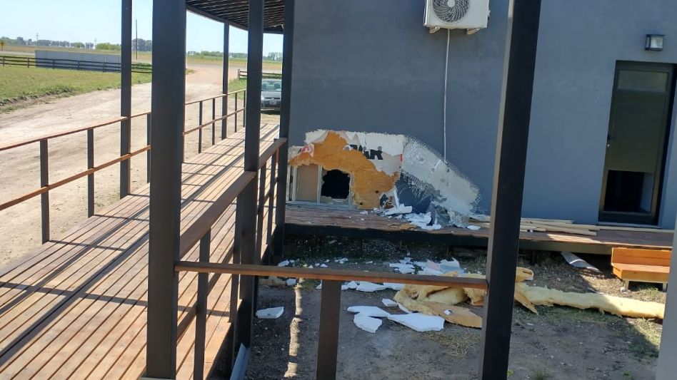 El hueco que los delincuentes hicieron en una de las oficinas, sobre la pared. Y en la imagen de abajo, el estado en que quedó la puerta de acero que violentaron.