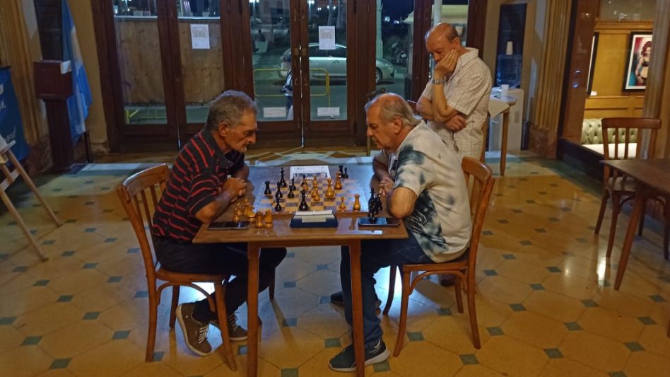 Alfredo Davis (izquierda) y Gustavo Godoy, duelo de capitanes, trenzados en el hall del Español y observados atentamente por el Dr. César Martínez. 