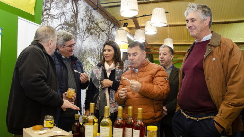 El intendente Hernán Bertellys y el Ministro de Desarrollo Agrario de la provincia de Buenos Aires, Javier Rodríguez, degustando miel en uno de los stands de la muestra apícola.