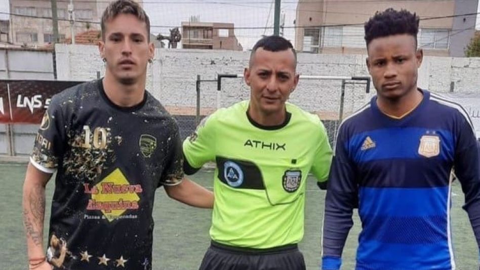 Alexander Williams Tapón extiende su brazo hacia la espalda del árbitro.