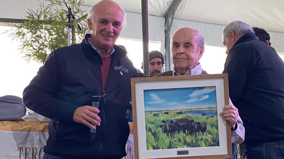El presidente de Angus, Alfonso Bustillo, premiando al histórico cabañero y titular de Tres Marías Horacio Francisco Gutiérrez. 