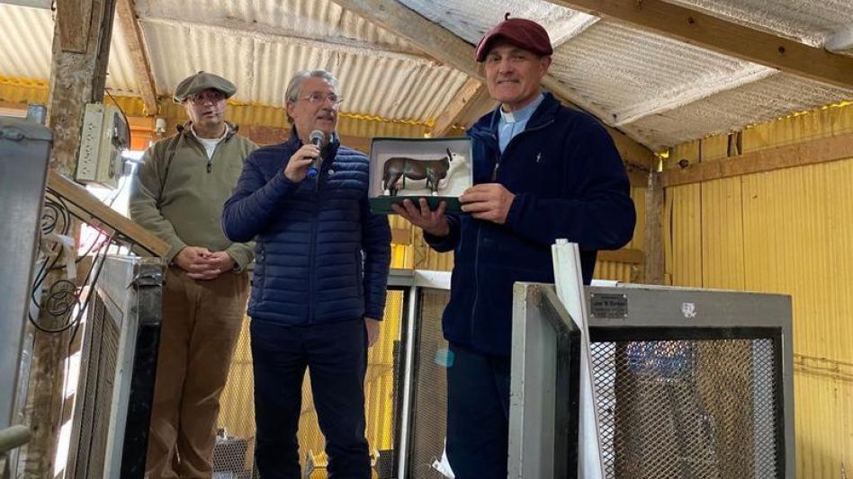 El padre Rubén Lacón exhibiendo el premio que le entregó el presidente de la AACH Jorge Colinet.   