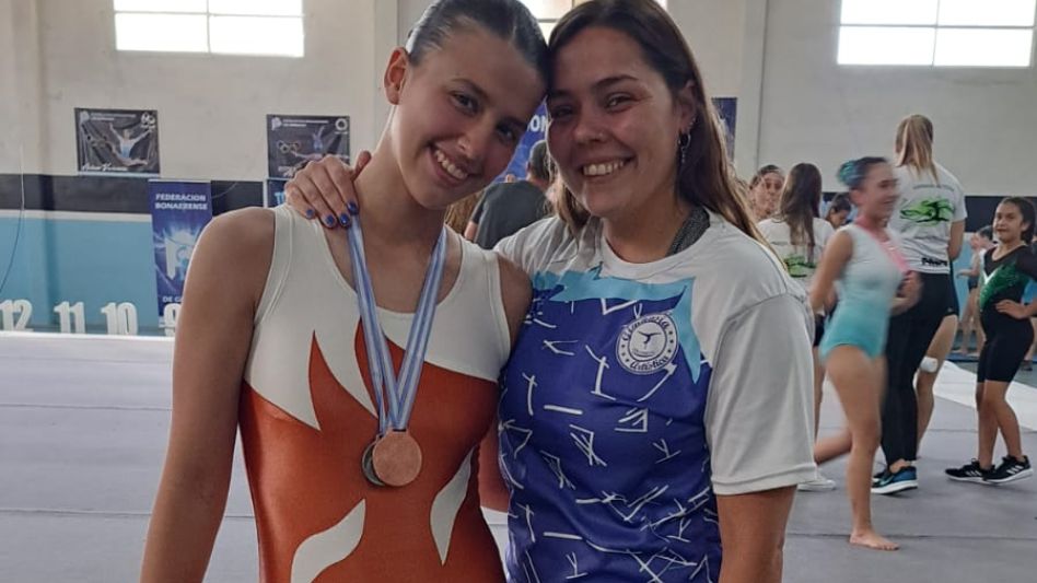 Angela Camino (izquierda) y Sara Pardheillan (derecha) posan junto a su entrenadora Caro Bongiorno.