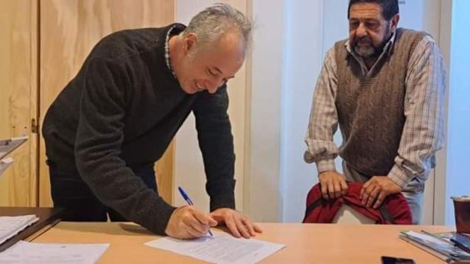 Leandro Ferraro, presidente del Consejo Escolar de Azul, y Pedro Benedicto, director del Centro de Formación Laboral 402, durante la firma del convenio.