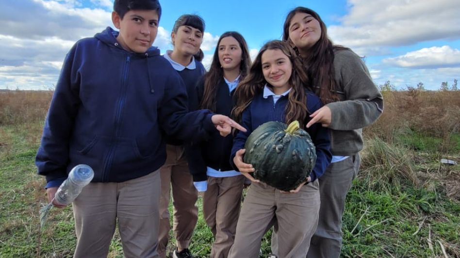 Los estudiantes de la Escuela Agraria de Azul posando junto al gran zapallo Cabutia que lograron cosechar.  GENTILEZA/ESCUELA AGRARIA