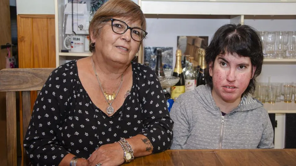 Ayelén Zapata tiene 33 años y padece múltiples condiciones de salud: hidrocefalia, paraplejía, epilepsia, síndrome de Wess y retraso psicomotor. En la imagen unto a Sylda, su mamá. 