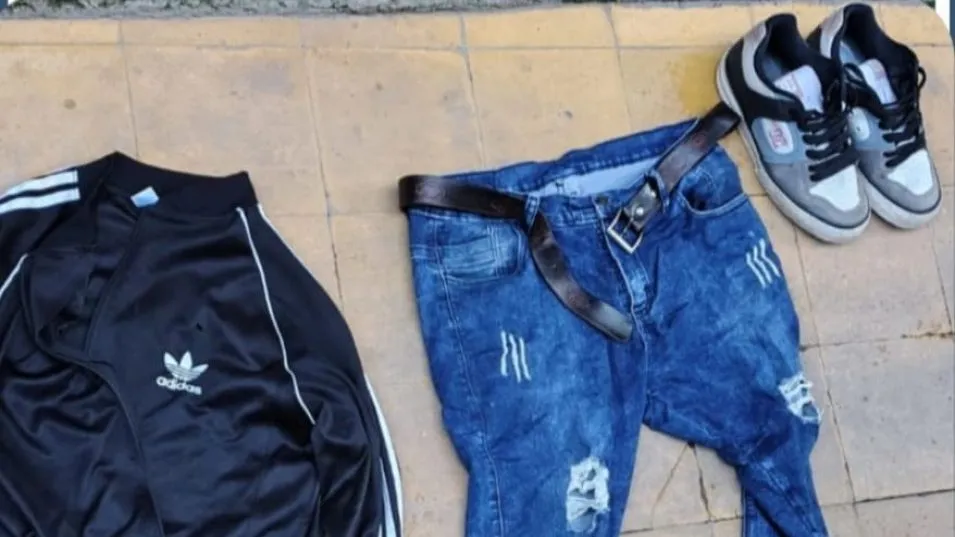 Prendas de vestir y un par de zapatillas, secuestrados durante un allanamiento en la casa del acusado. FOTO: EPDS AZUL/PBA